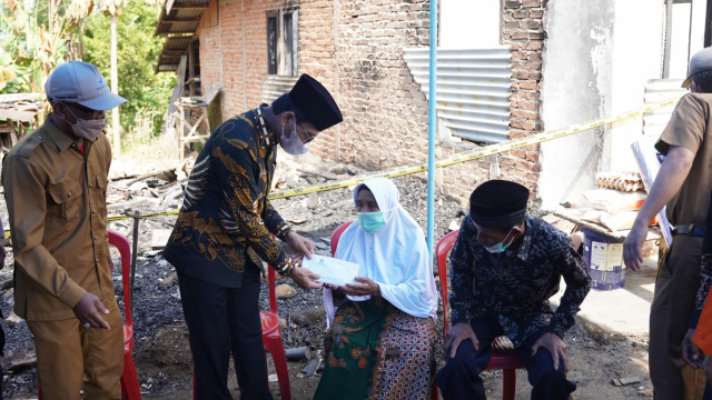 Bupati Limapuluh Kota Safaruddin Dt. Bandaro Rajo, saat memberikan bantuan kepada Nurbaina (70) warga Jorong Kubang Bungkuak, Nagari Situjuah Batua, Kecamatan Situjuah Limo Nagari yang mengalami musibah kebakaran rumah
