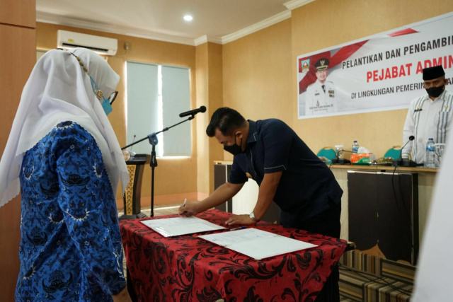 Bupati Dharmasraya Sutan Riska Tuanku Kerajaan menandatangani surat keputusan penetapan jabatan.