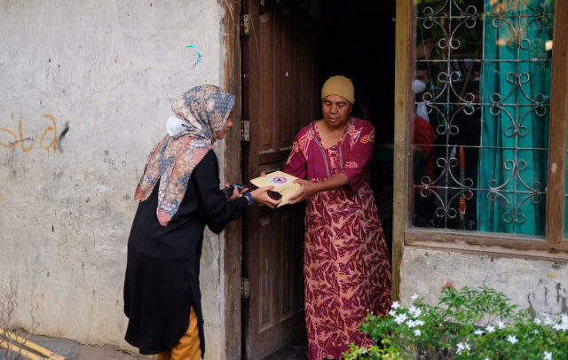 Kepala Unit Humas & Kesekretariatan PT Semen Padang Nur Anita Rahmawati  menyerahkan nasi kotak untuk berbuka kepada salah seorang warga Koto Tingga Dalam, Jumat.