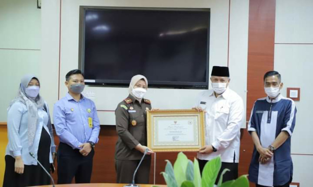 Wali Kota Solok Zul Elfian menyerahkan penghargaan kepada Kajari Solok Feni Nilasari.
