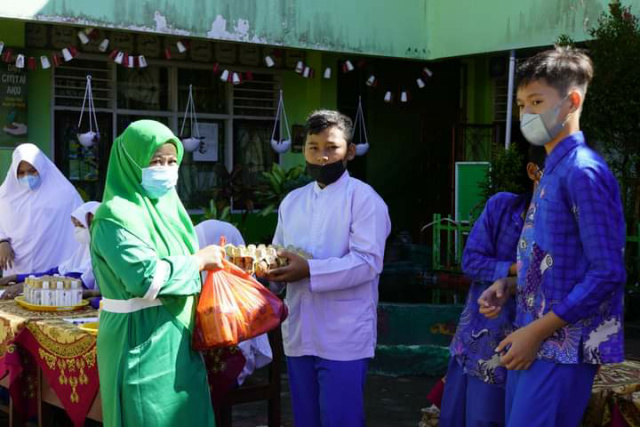 Siswa SD Negeri 3 Padang Panjang Barat bagikan paket Sembako Lebaran, Jumat (22/4/2022) di halaman sekolah.