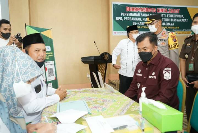 Bupati Dharmasraya Sutan Riska Tuhanku Kerajaan, disusul Forkopimda, Kepala OPD, tokoh masyarakat, saat menyerahkan Zakat kepada Baznas Dharmasraya