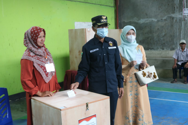 Bupati Safaruddin bersama istri ketika memberikan hak suara pada Pilwanag di TPS 6 Nagari Baruah Gunuang