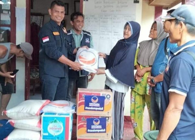 Ketua DPD Nasdem Pasaman, Ahmad Khadafi saat serahkan bantuan sembako