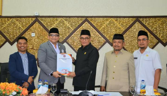 Ketua DPRD Padang Syafrial Kani serahkan Perda Penyelenggaraan Transportasi Darat usai disahkan. 