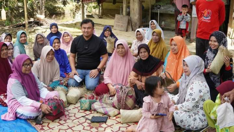 Bupati Dharmasraya Sutan Riska Tuanku Kerajaan Ikut serta menganyam saat berada di tengah kaum lansia
