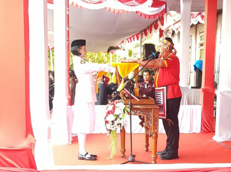 Pj Bupati Menyerahkan Bendera kepada Pembawa Baki Pasukan Pengibaran Bendera Merah Putih