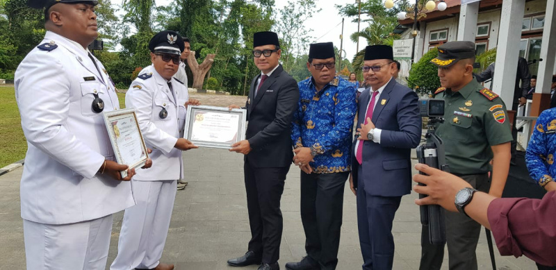 Bupati Kep.Mentawai DR.Rinto Wardana memberikan Penghargaan kepada Kepala Desa Bukit Pamewa Utoyo Ali Rahman sebagai pendirian tercepat Koperasi merah putih di Kep.Mentawai