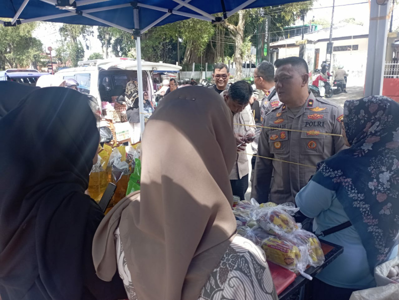 Wakapolres Kompol Yulandi melayani masyarakat saat membeli beras. (chandra antoni)