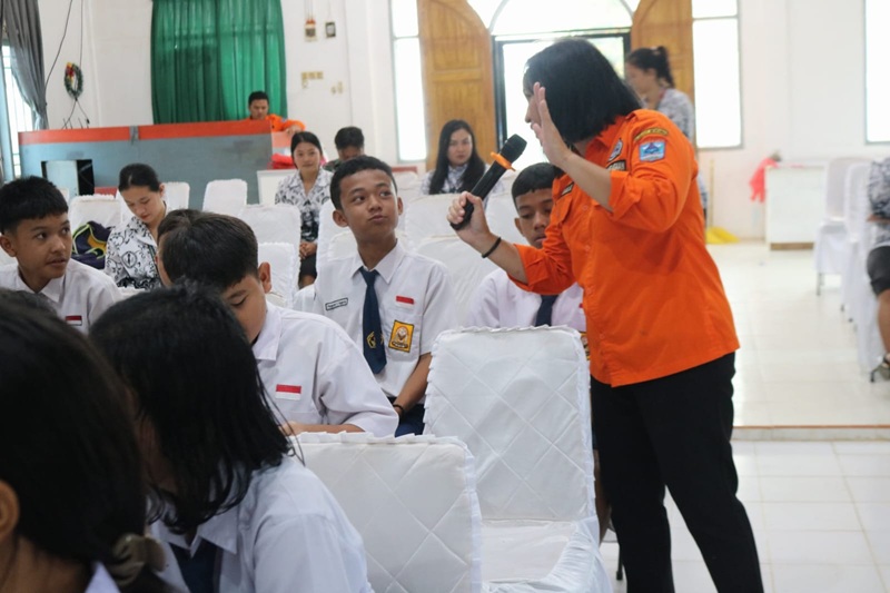 Tim satgas tmmd ke130 sedang memperagakan penyelamatan diri sangat terjadi bencana kepada anak sekolah yayasan cahaya bangsa
