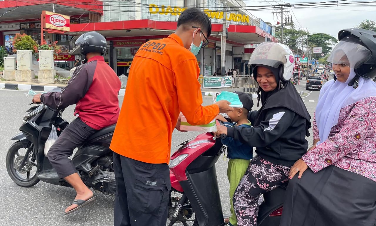 Petugas BPBD saat bagikan masker pada pengendara sepeda motor depan simpang empat PDAM, Kamis kemaren.