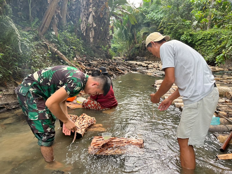Dan Satgas sedang mengambil  Toek di Pohon yang terendam didalam air dan makanan ini siap santap tanpa dimasak , Anggota Tim Satgas TMMD lagi menikmati Makan Toek