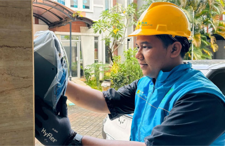 Ilustrasi petugas PLN saat melakukan pemasangan home charger di rumah pelanggan untuk memudahkan pengisian kendaraan listrik di rumah